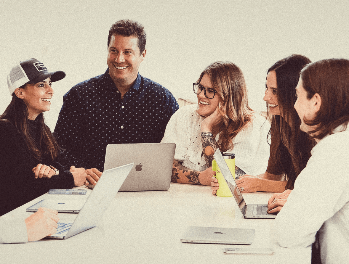 Creed team members huddled around a table