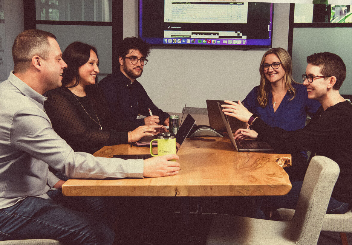 Creed team members working on a project in a meeting room