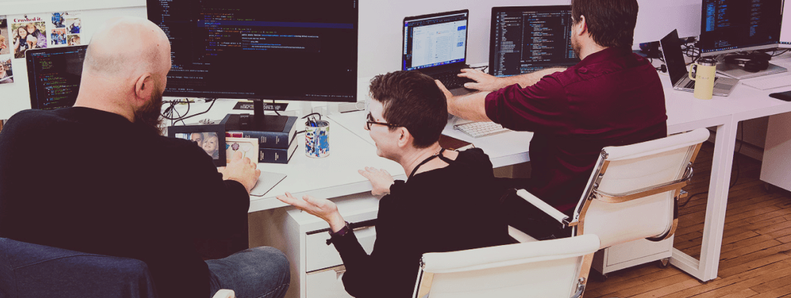 Developers chatting in front of their desktops