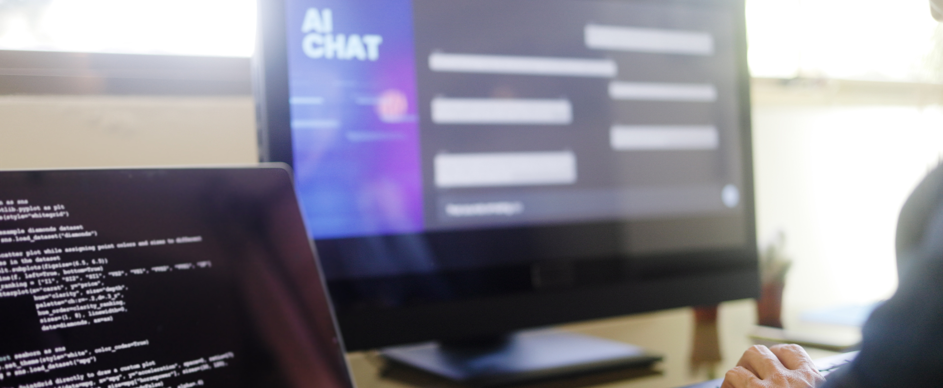 Two computer monitors, one with coding, the other with "AI Chat" on the screen.