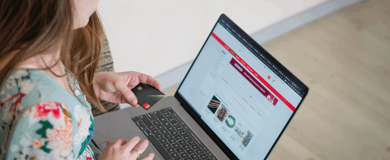 Person looking at a website on laptop with credit card in hand