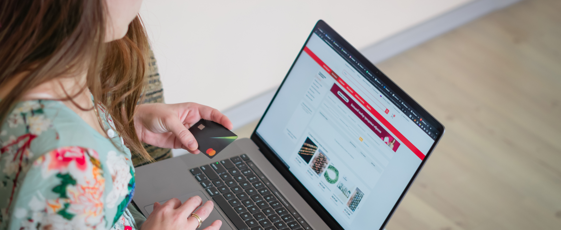Person looking at a website on laptop with credit card in hand