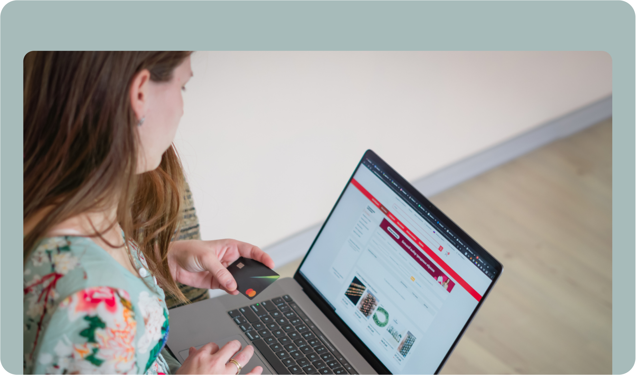 Person looking at a website on laptop with credit card in hand