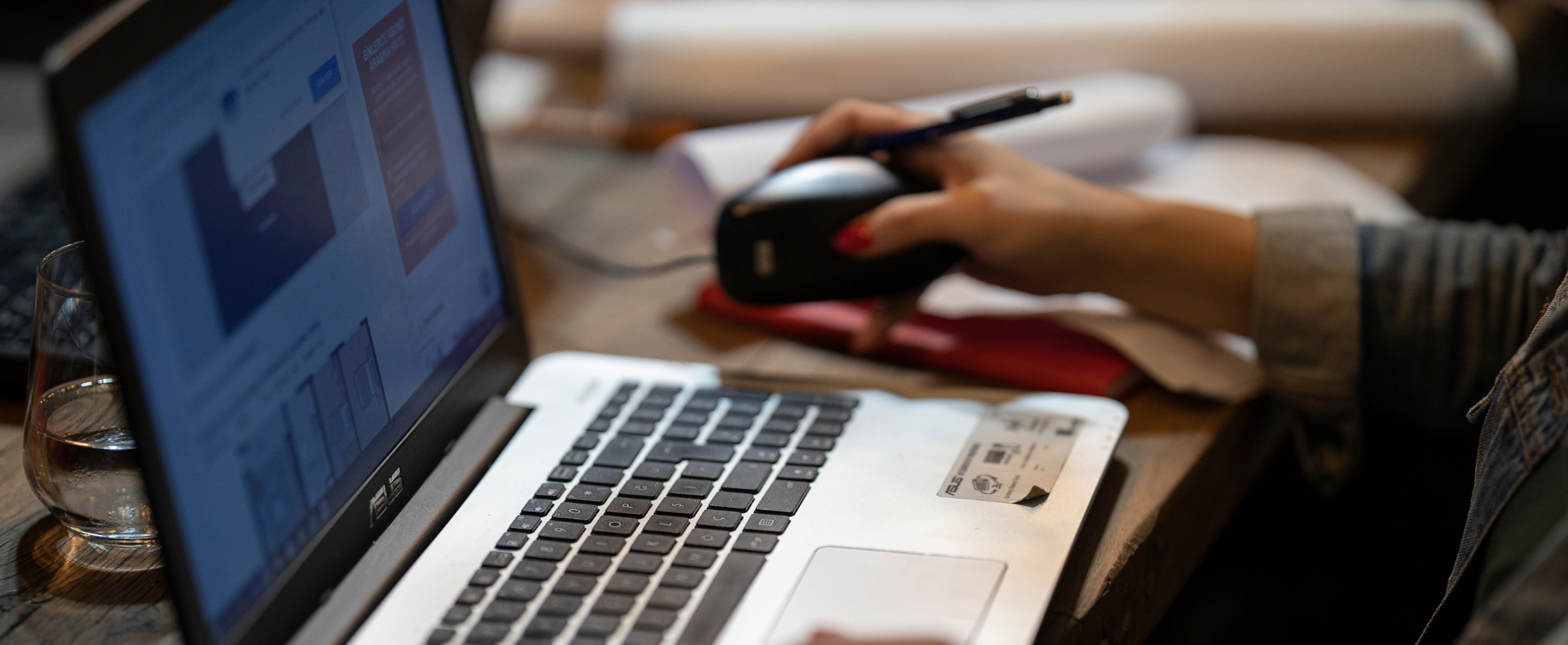 Hand at mouse with laptop